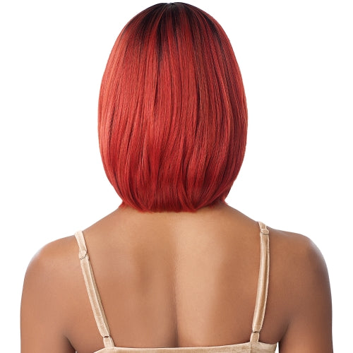 Back view of a model wearing Outre WIGPOP KALISSA wig, a sleek, straight, chin-length fiery red bob with dark roots.