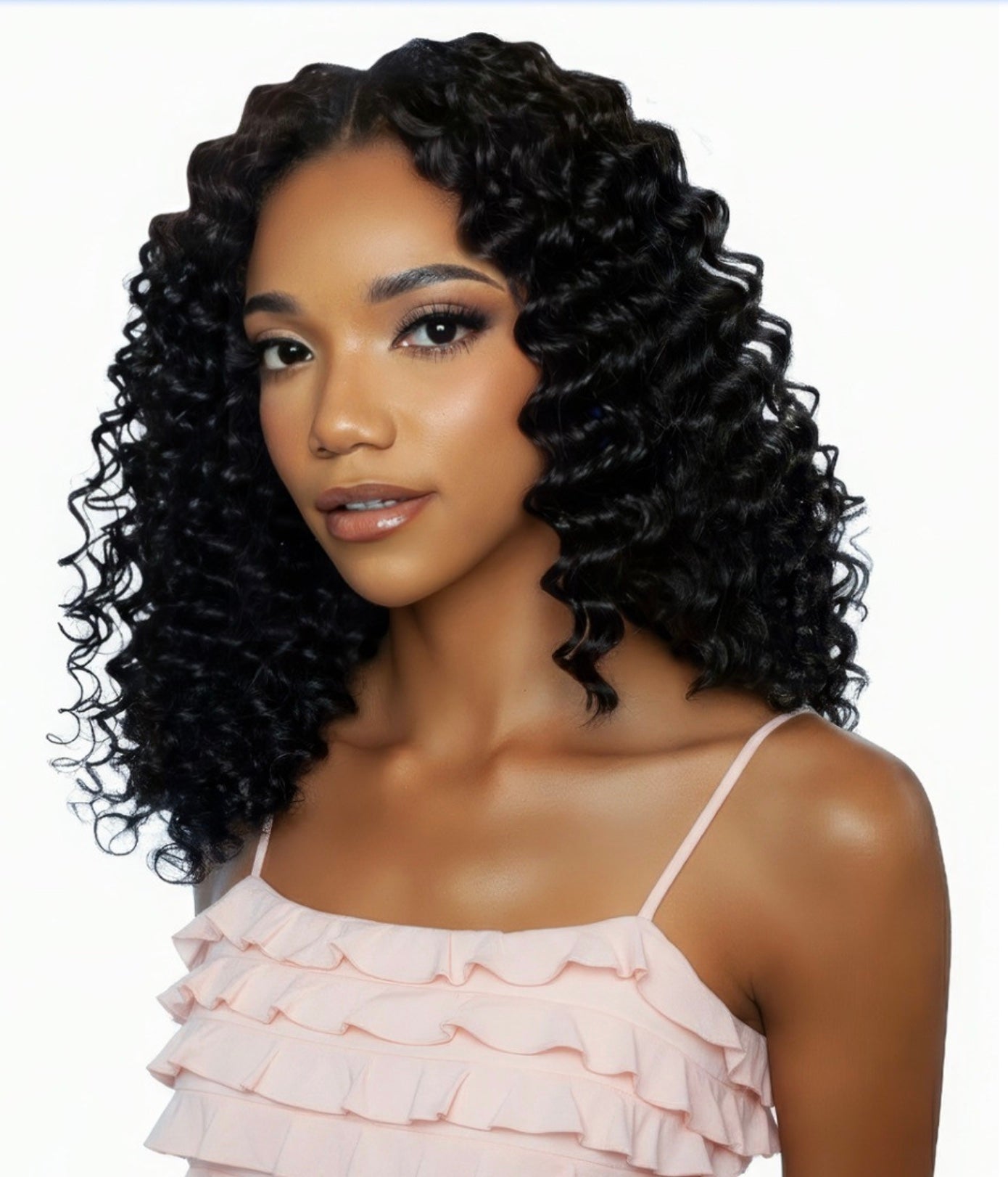 A woman models Pristine Micro Crochet Deep Wave 12" human hair. Her black, glossy, defined curls fall to her shoulders.
