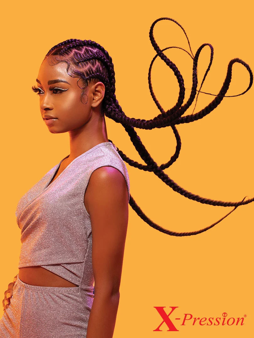 Woman in profile with dark X-Pression Braid cornrows. Ultra-long braids are intricately styled, flowing dramatically.