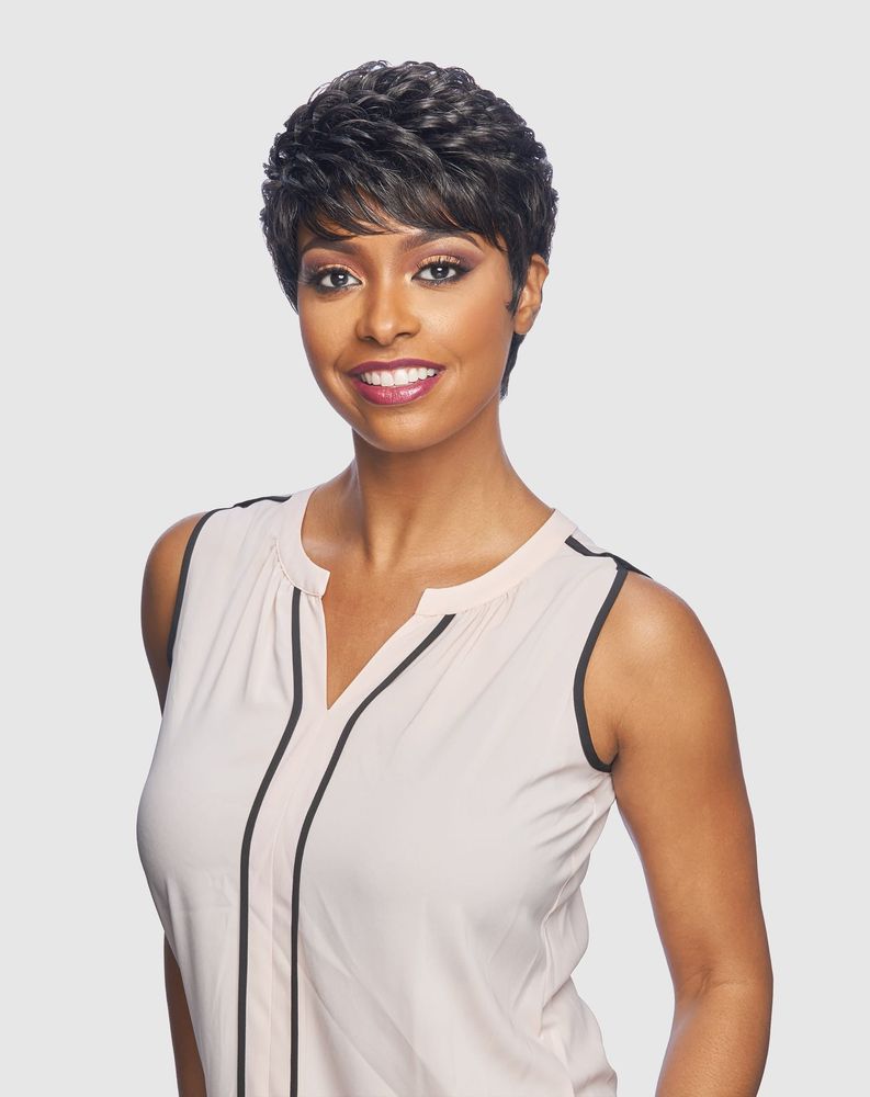 Smiling woman models Vanessa BRANDY Synthetic Wig: short, dark, wavy pixie cut with bangs.
