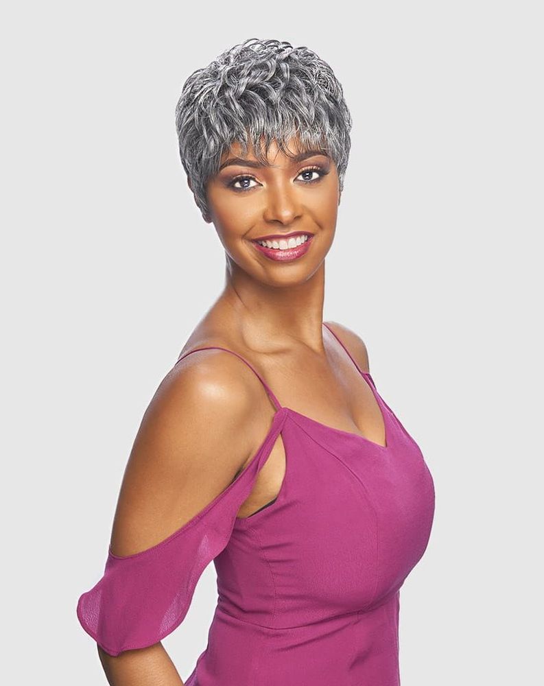 Smiling woman wears Vanessa CABO Synthetic Wig β Quick Volume: a short, curly, silver pixie with bangs.