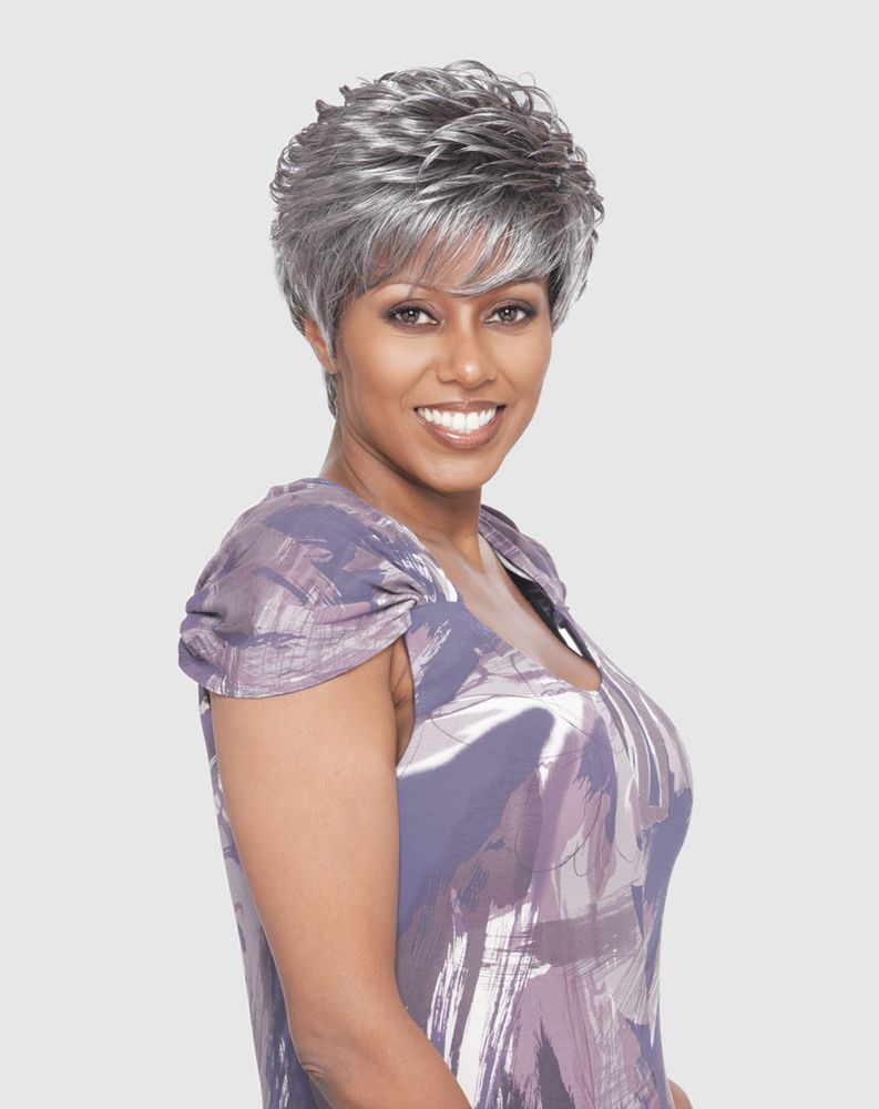 Smiling woman models Vanessa CALI Synthetic Wig with short, voluminous silver curls and a styled pixie cut.