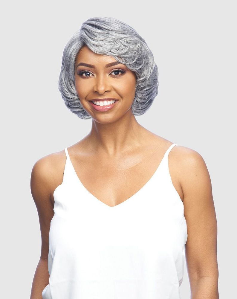 A smiling woman showcases the DJ JENINE wig: a short, silver, voluminous bob with side-swept waves.