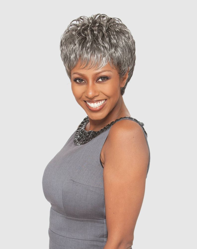 Smiling woman wears the Vanessa RAMIE Synthetic Wig, a short, spiky, silver-grey pixie with bangs.