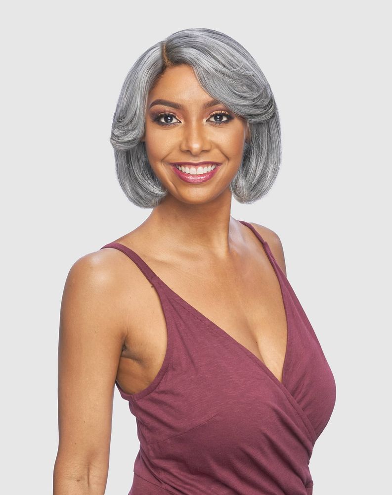 Smiling woman wearing the Vanessa SUPER C KELLY Synthetic Wig, a short, silver-grey bob with bouncy, curled ends and a sid...