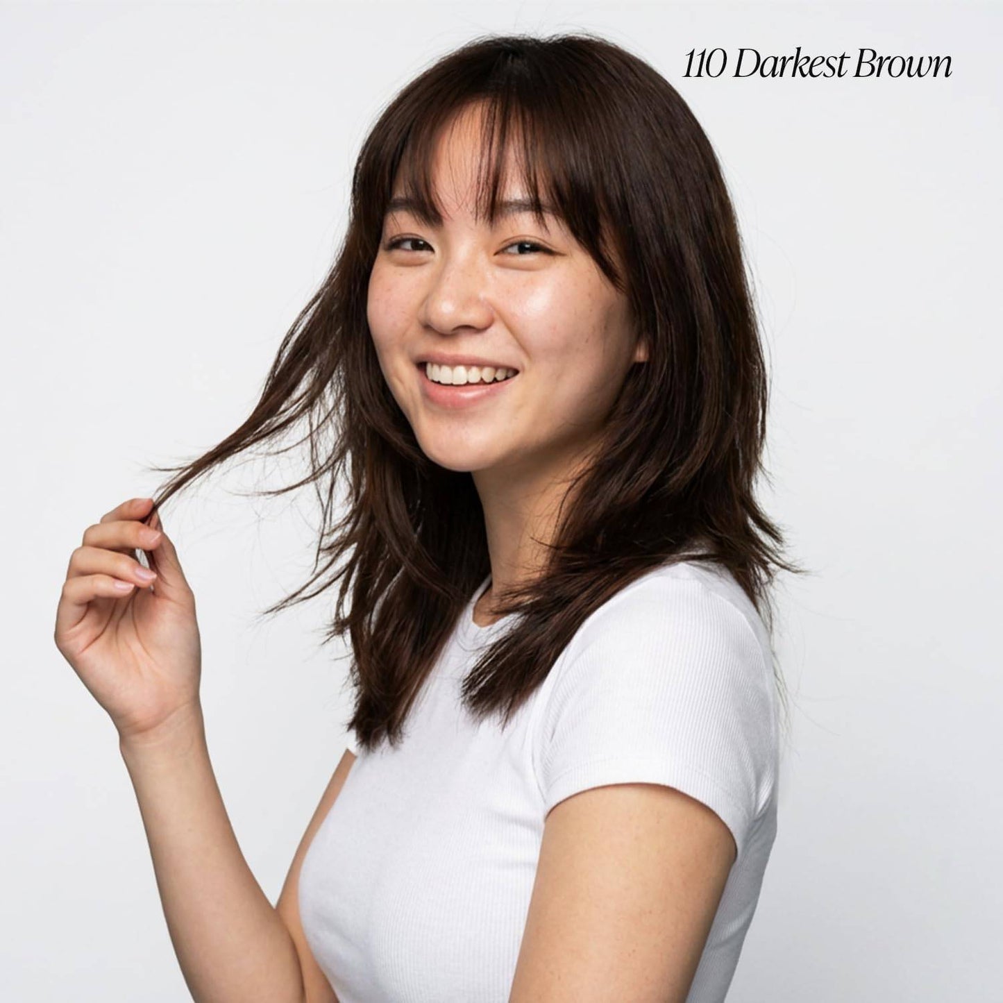 Smiling woman with shoulder-length Creative Image Adore #110 Darkest Brown layered hair and bangs.