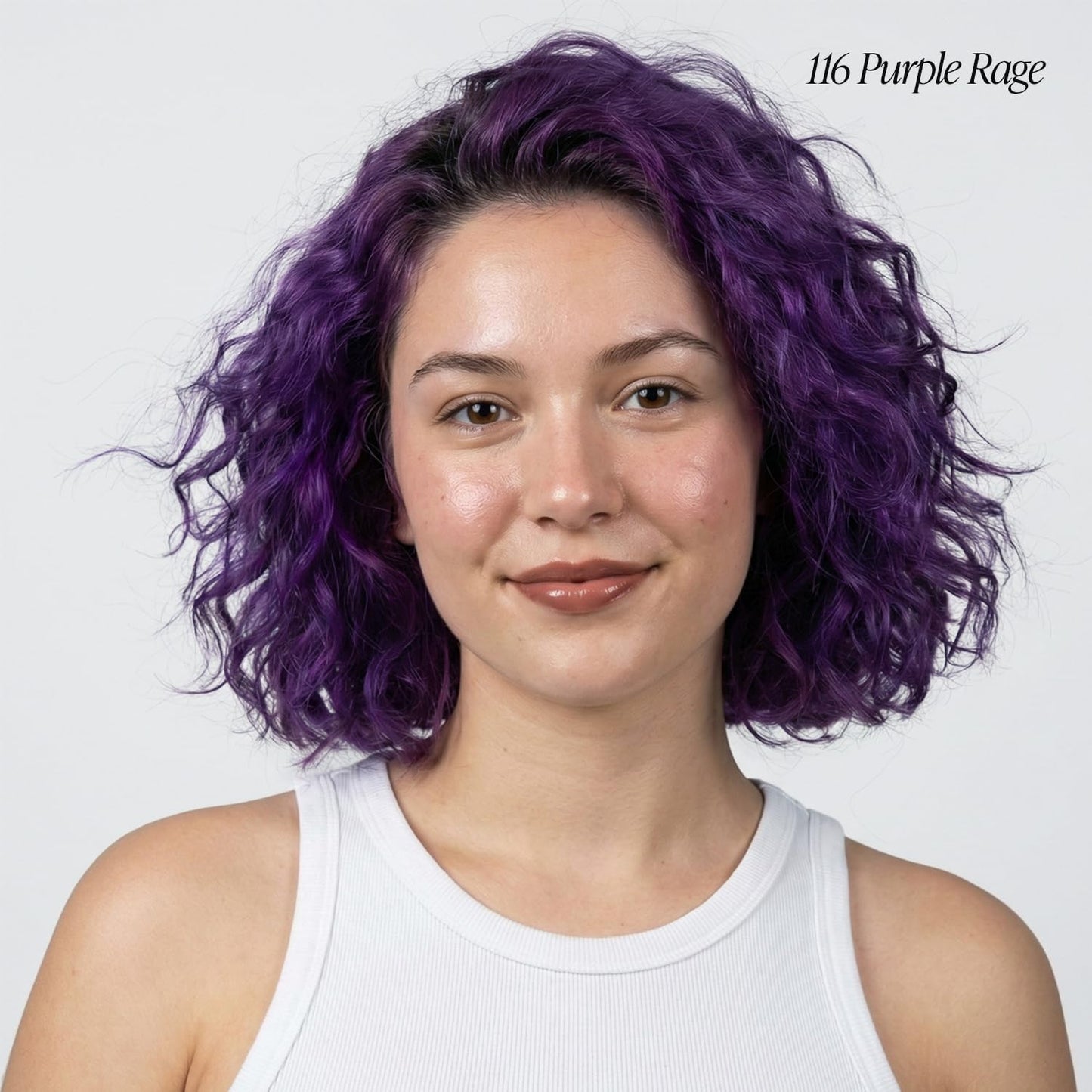 A woman models Creative Image Adore Semi-Permanent Hair Color #116 Purple Rage, a vibrant purple curly bob.