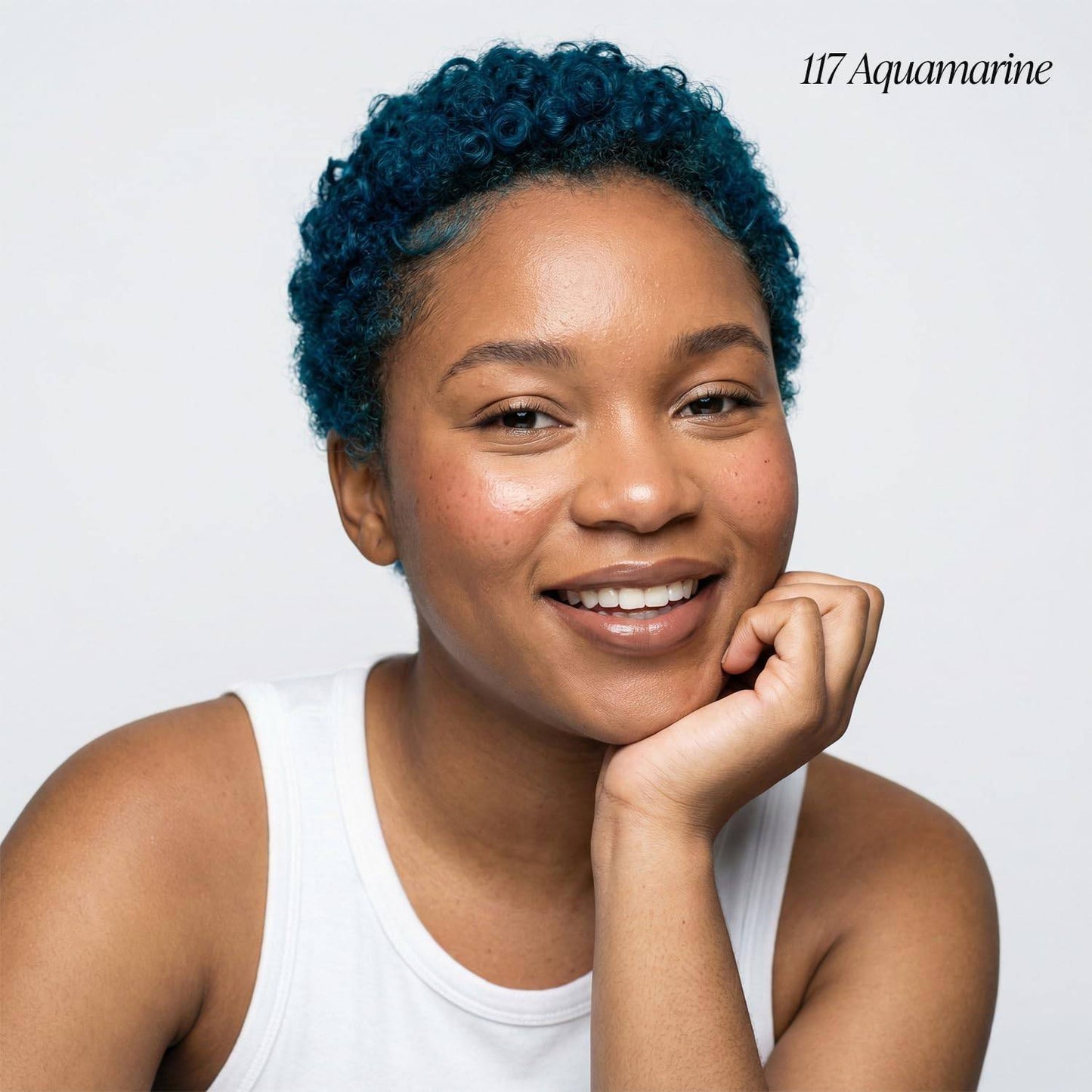 Smiling woman with short, curly aquamarine hair, showcasing Creative Image Adore Semi-Permanent Hair Color #117 Aquamarine.