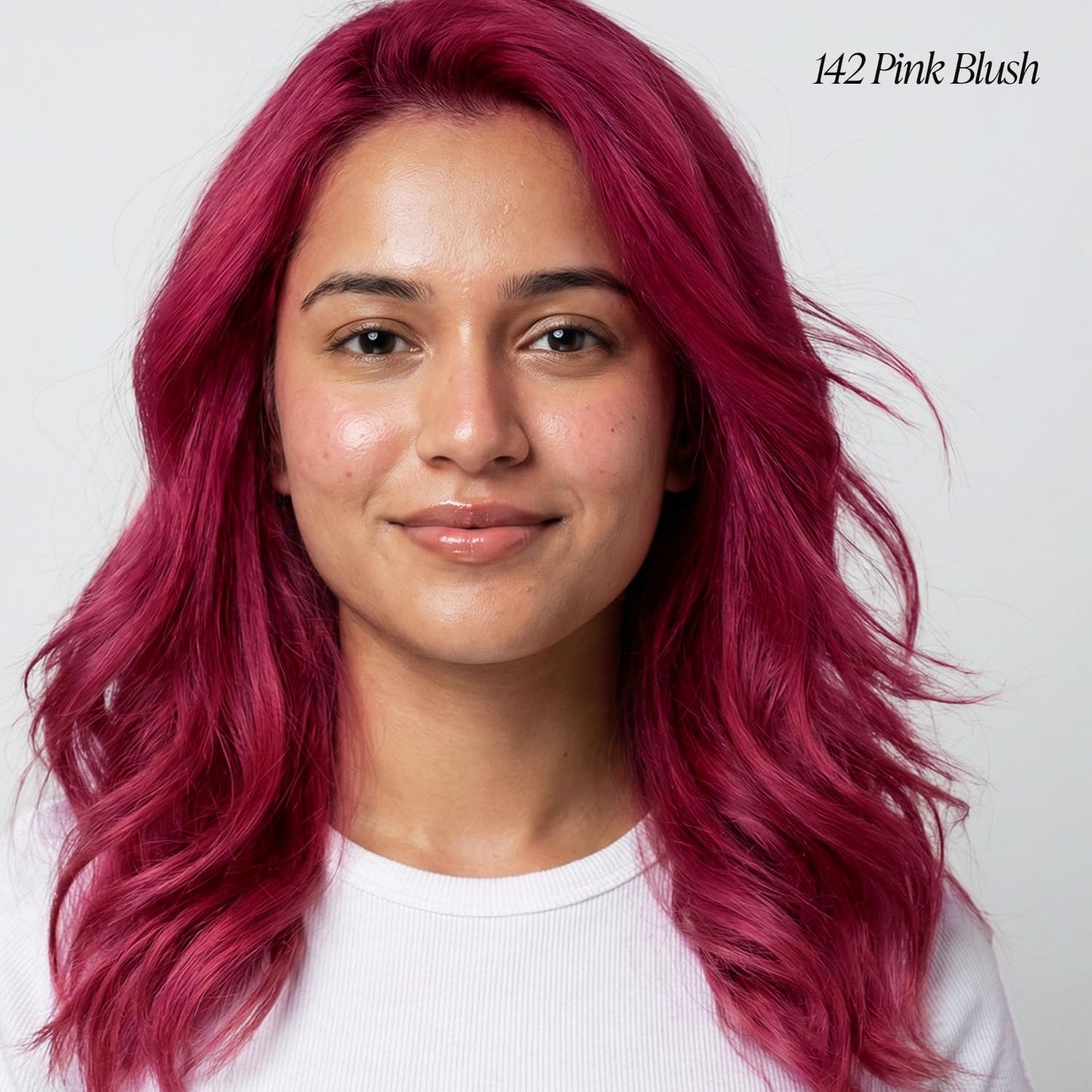 Smiling person with vibrant, wavy, medium-length hair colored Creative Image Adore Semi-Permanent #142 Pink Blush.