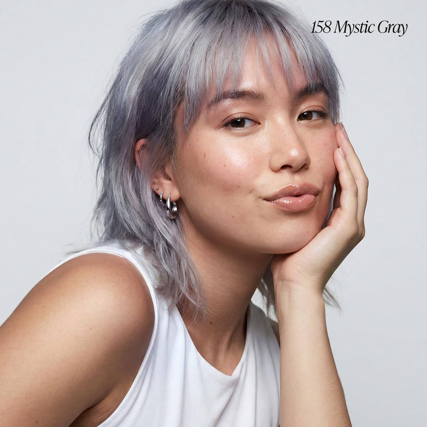 A woman models Creative Image Adore #158 Mystic Gray semi-permanent hair color. Her short, shaggy hair with bangs is a pal...