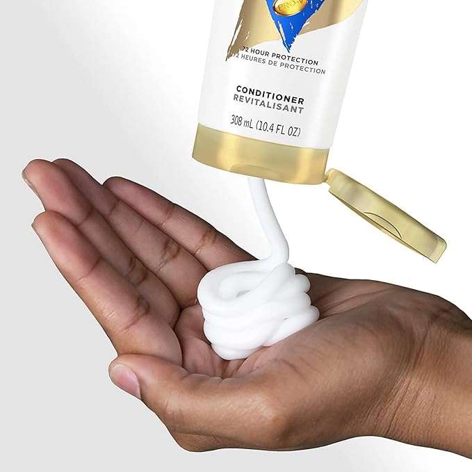 White Pantene Pro-V Repair & Protect Conditioner dispensed from its bottle onto a person's open hand.