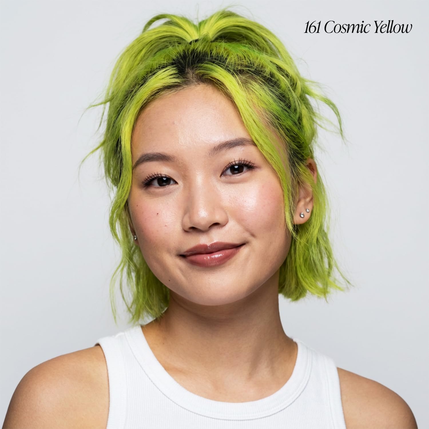 Smiling young woman with short, bright #161 Cosmic Yellow hair by Creative Image Adore, styled in a messy bob with face-fr...