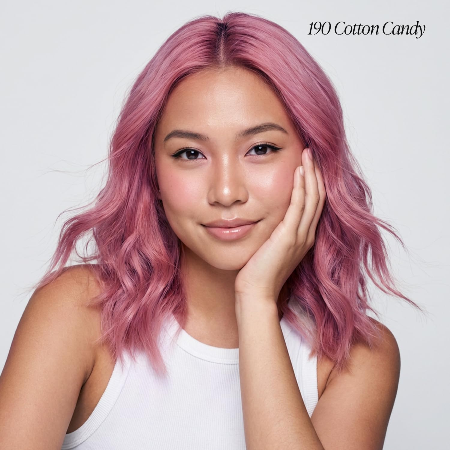 Smiling woman models Creative Image Adore #190 Cotton Candy hair color: wavy, shoulder-length, vibrant pink hair
