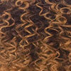 Close-up of X-PRESSION BRAID hair: tight, bouncy curls in dark brown and warm golden blonde.