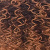 Close-up texture swatch of X-PRESSION BRAID pre-stretched hair: tight dark brown to copper curls.