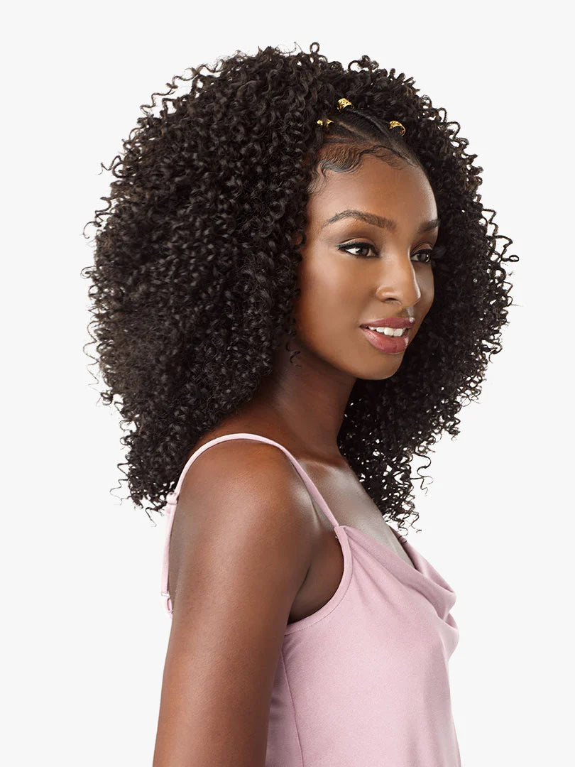 Woman models voluminous, shoulder-length Lulutress 2X Coily 3C dark curly hair, styled with gold beads.