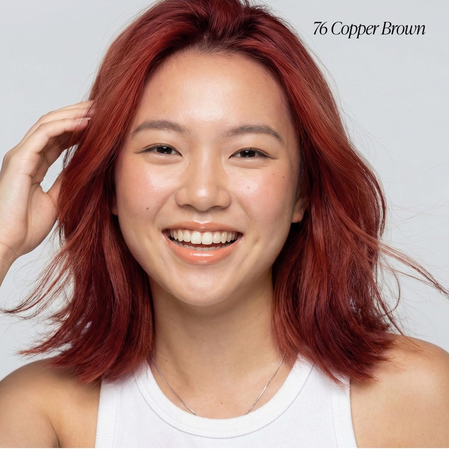 Smiling woman displaying a shoulder-length, wavy hairstyle colored Creative Image Adore #76 Copper Brown.