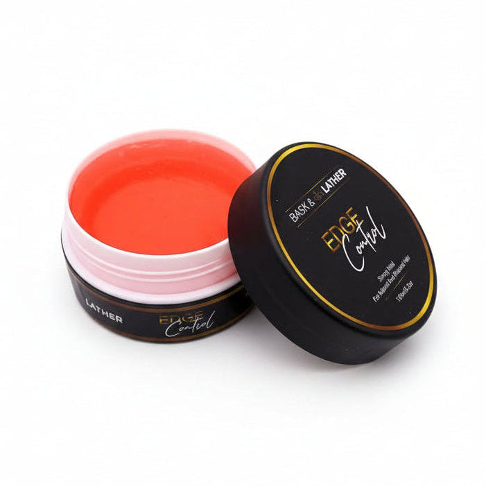 Open black jar of Bask & Lather Edge Control reveals bright orange gel inside. The black lid with gold text sits next to it.