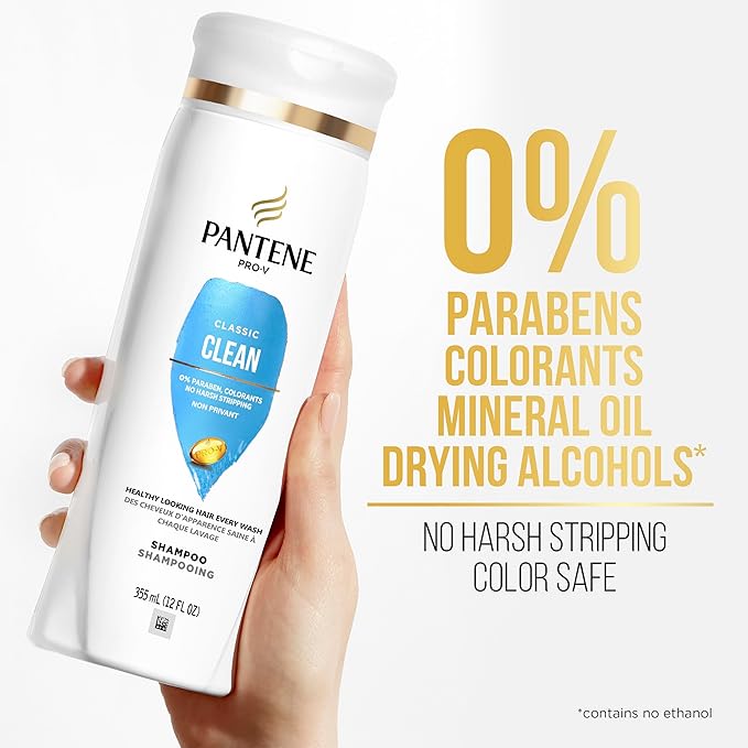 A person's hand holds a white Pantene Pro-V Classic Clean Shampoo bottle. Text highlights 0% Parabens, Colorants, Drying A...