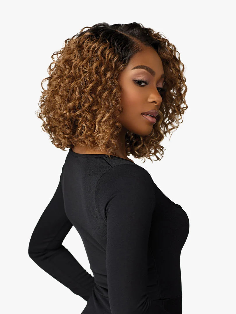 Woman wearing Butta Chic Bob Lace Wig, a voluminous, curly, chin-length ombre bob with dark roots and honey blonde hair.