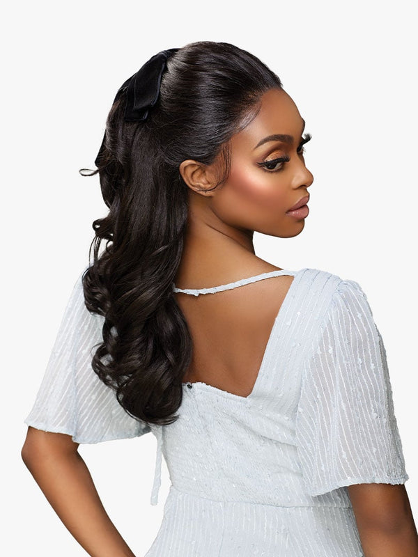 Sensationnel GLAMORA LACE WIG - GLAM UNIT 1: Model with long, dark wavy half-updo, tied with a black bow.