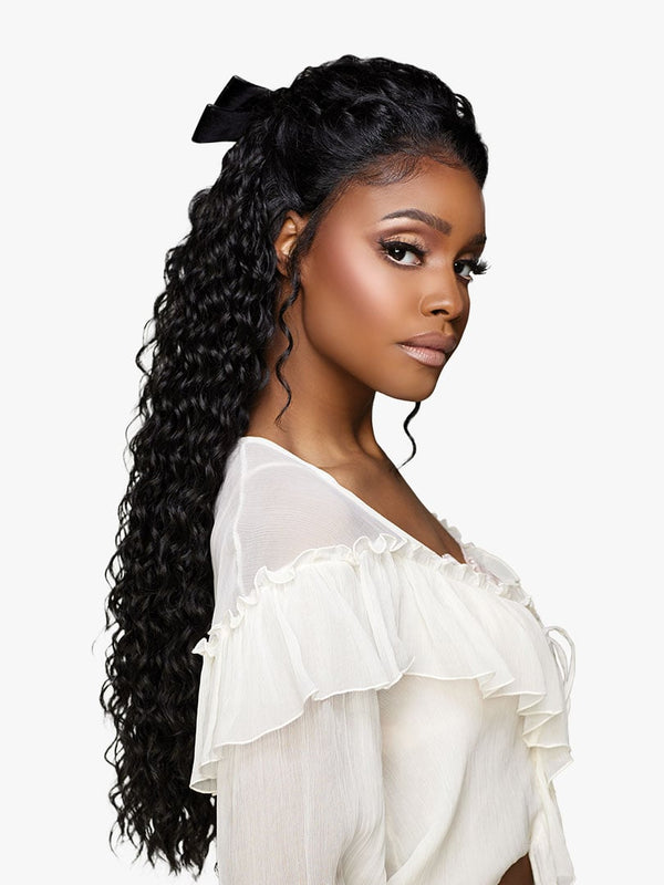 Woman wearing Sensationnel GLAMORA LACE WIG - GLAM UNIT 2, long black wet & wavy hair styled half-up with a black bow.