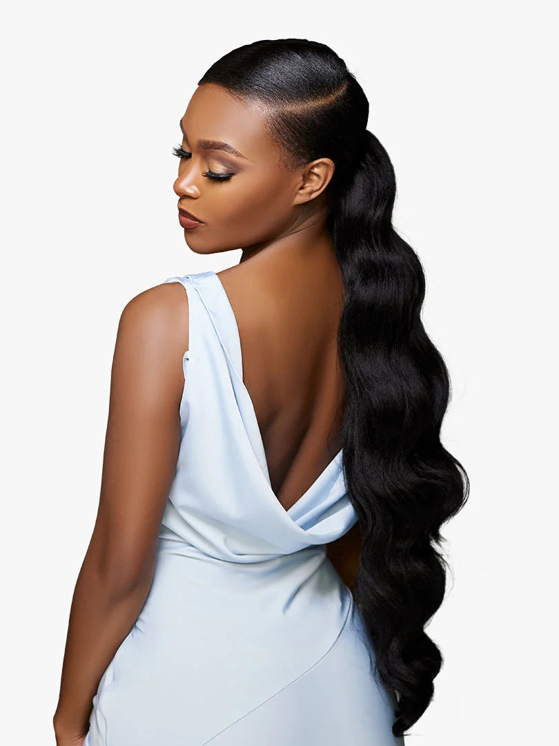 Woman models GLAMORA Glam Updo Unit 6: long, wavy black hair in a sleek, side-parted low ponytail.
