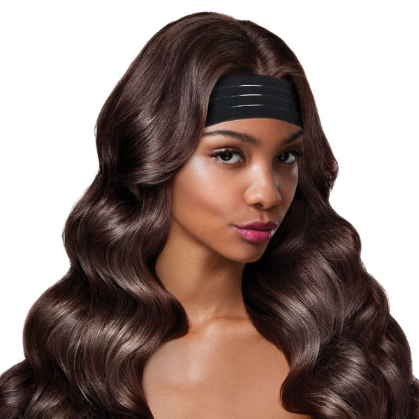 A woman wears a Red by Kiss Perfect Melt Wigband. Her long, wavy dark brown hair flows back from the black elastic band.