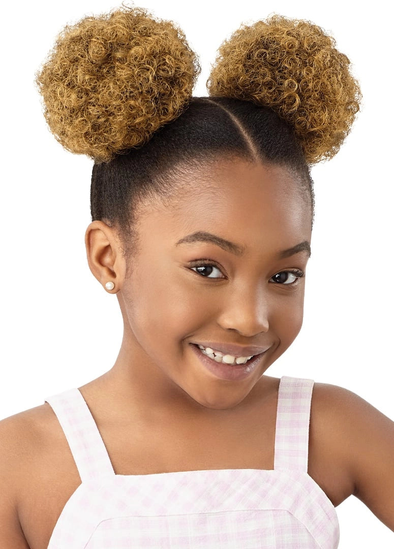 A smiling girl wears LIL LOOKS Mini Duo Puffs. Her dark hair is styled with two voluminous, light brown curly top buns.