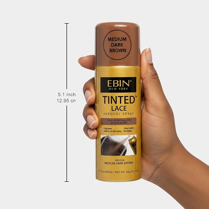 Dark hand holds EBIN Tinted Lace Aerosol Spray, a gold and brown can for Medium Dark Brown. Product height is 5.1 inches.