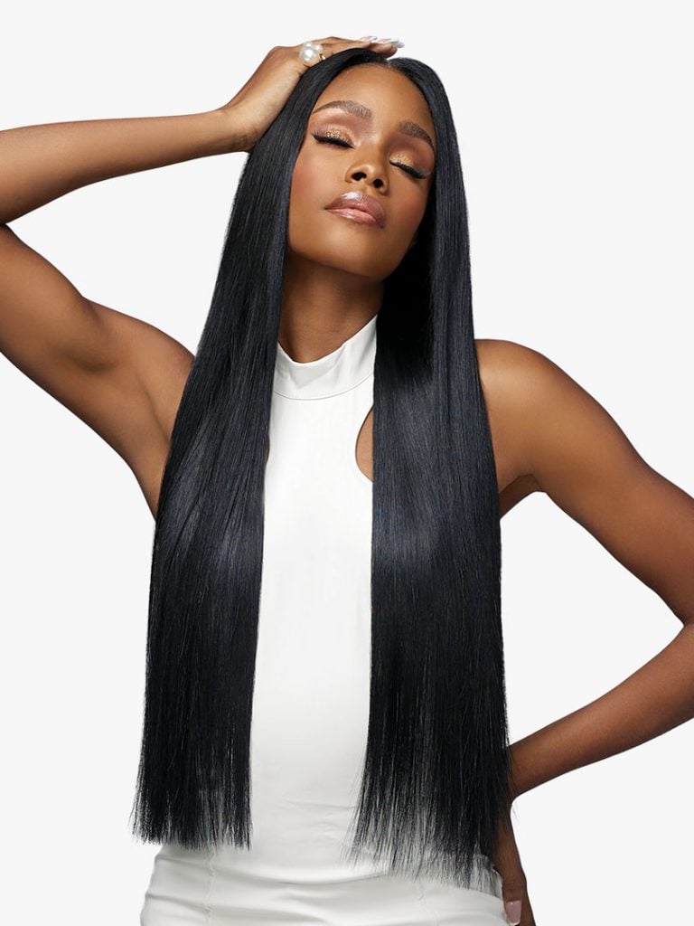 Model wearing Pearlish Virgin Remy Human Hair. Her long, sleek, straight black hair has a side part and flows past her waist.