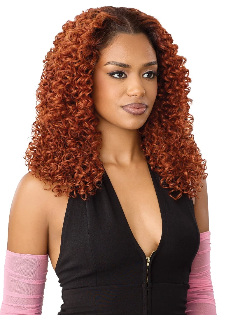 Woman wearing Perfect Hairline Lace Front Wig in Peak 716 HT, featuring voluminous, medium-length copper curls with a side...