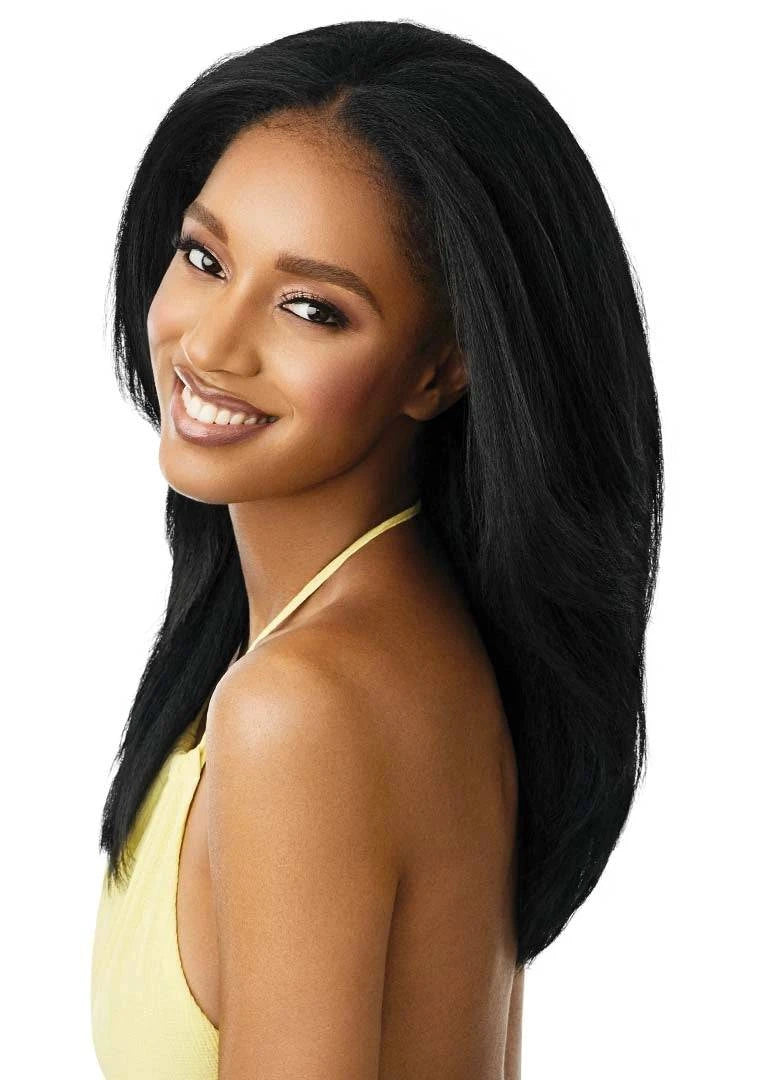 Smiling woman models Outre Hawaiian Hottie half wig: long, black, natural textured hair with a voluminous side part, flowi...