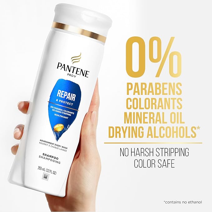 Hand holding white Pantene Pro-V Repair & Protect Shampoo bottle with blue label. Prominently shows '0% Parabens'.
