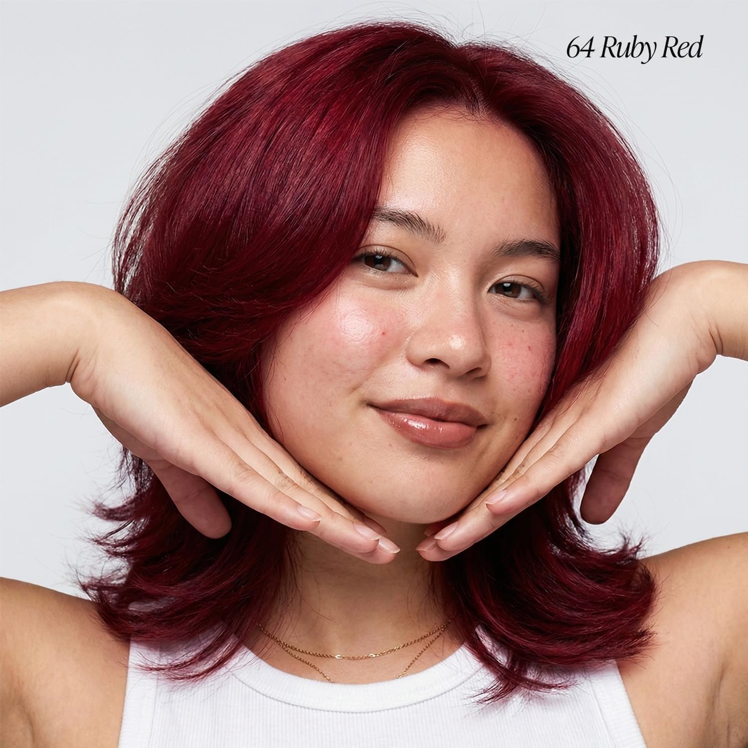 Smiling person with voluminous Creative Image Adore #064 Ruby Red hair, medium-length and wavy, framing their face.