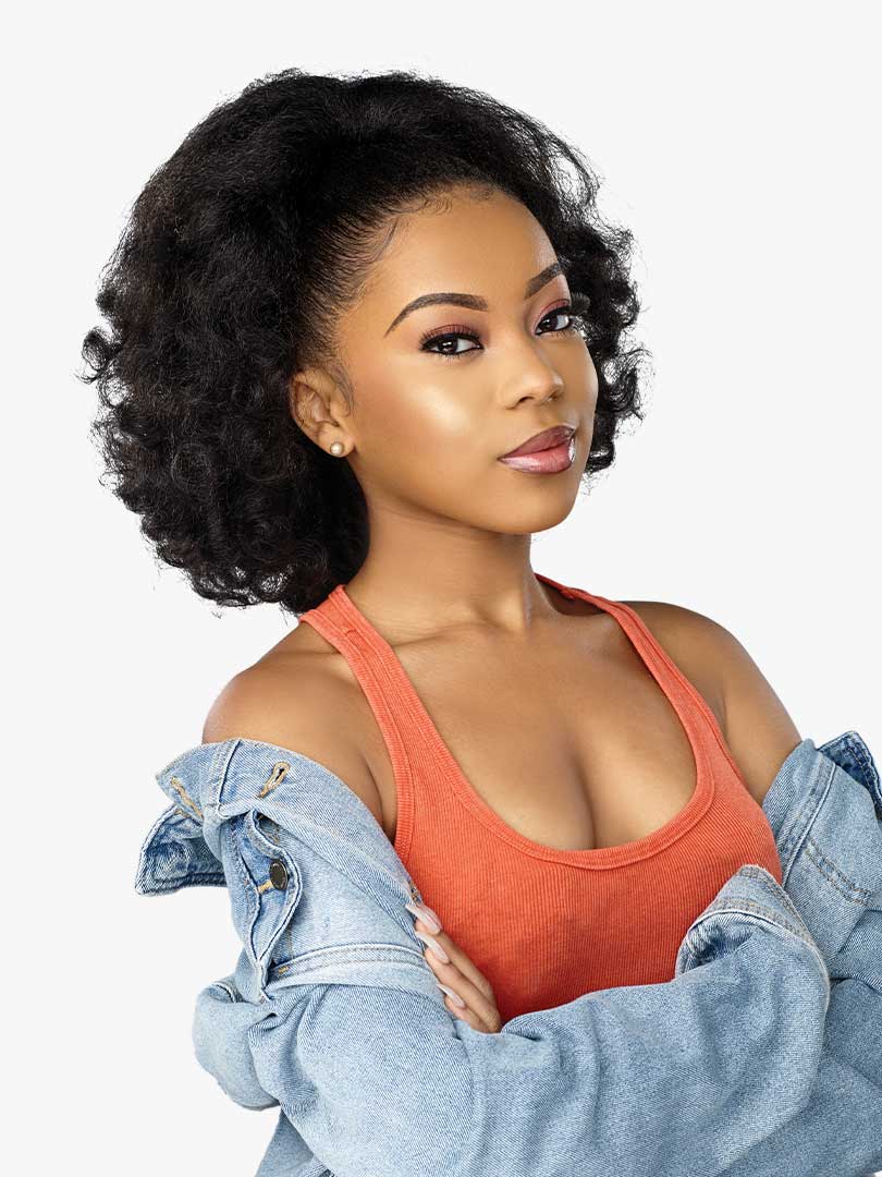 A woman models the Curls Kinks & Co Rain Maker Textured Drawstring Ponytail. She has a voluminous, dark, kinky-curly hairs...