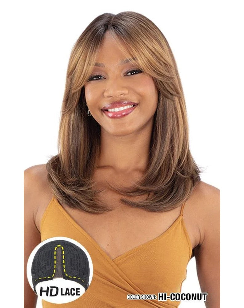 Smiling woman wears Freetress Equal HD Lace Front Wig. Medium layered brown hair with blonde curtain bangs, color HI-COCONUT.