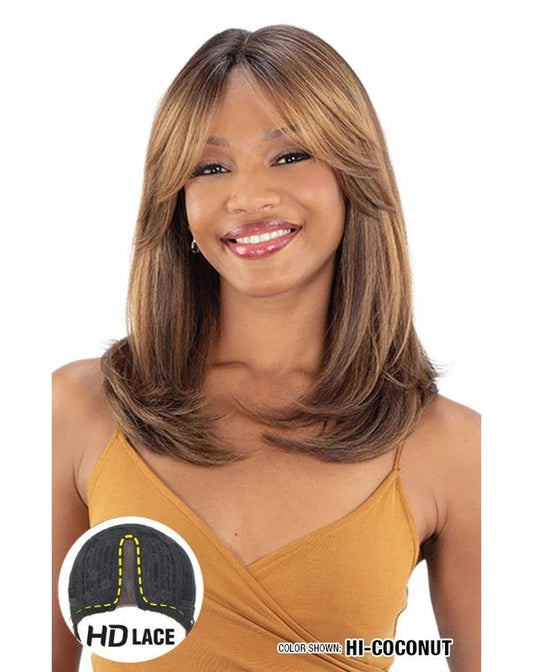 Smiling woman wears Freetress Equal HD Lace Front Wig. Medium layered brown hair with blonde curtain bangs, color HI-COCONUT.