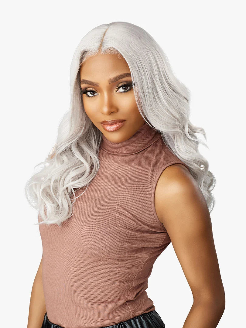 Woman models Shear Muse Gold Krush Glueless Lace Front Wig - Lanisha: shoulder-length, wavy, silver hair with a center part.
