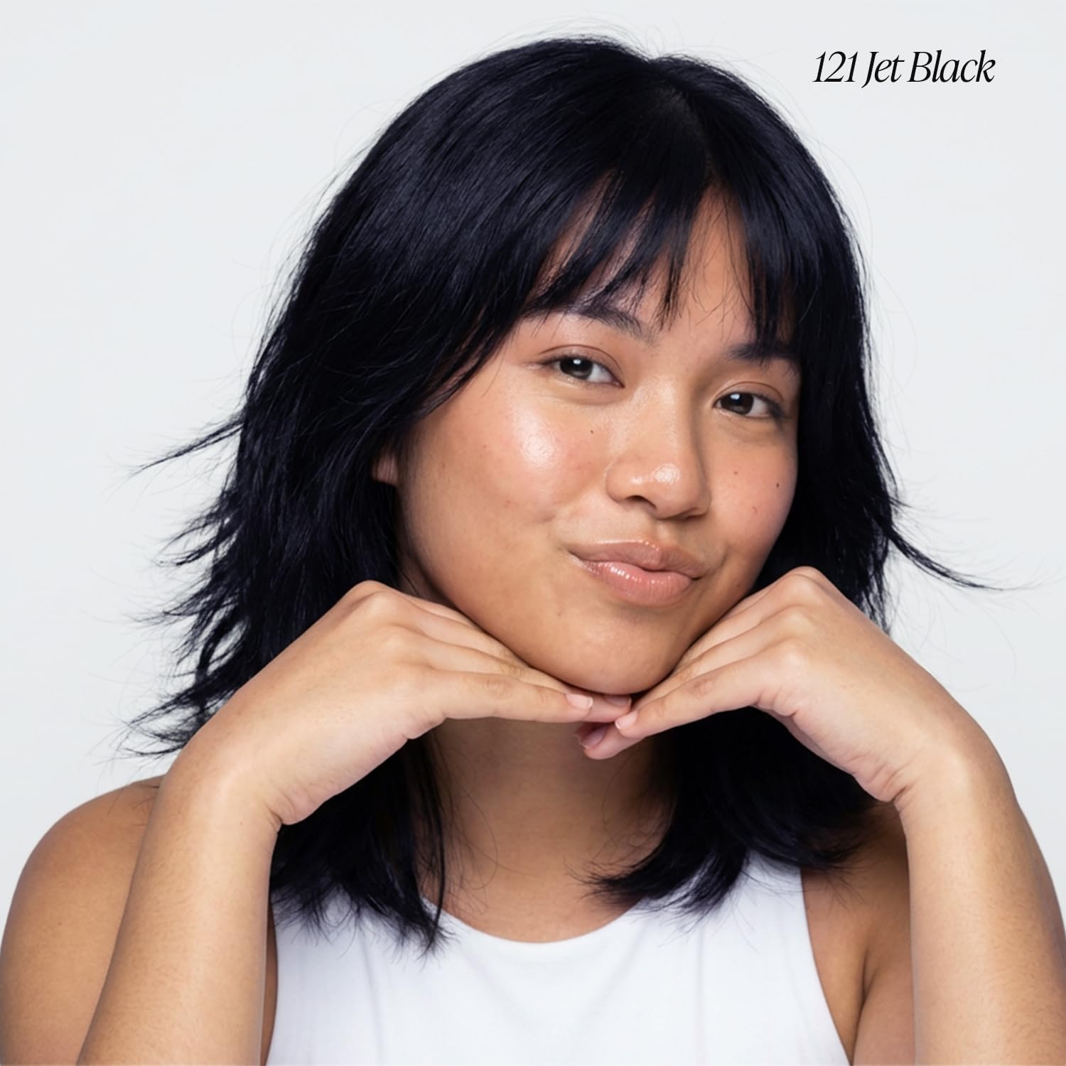 A model wears Creative Image Adore Jet Black semi-permanent hair color, shoulder-length layered hair with bangs.
