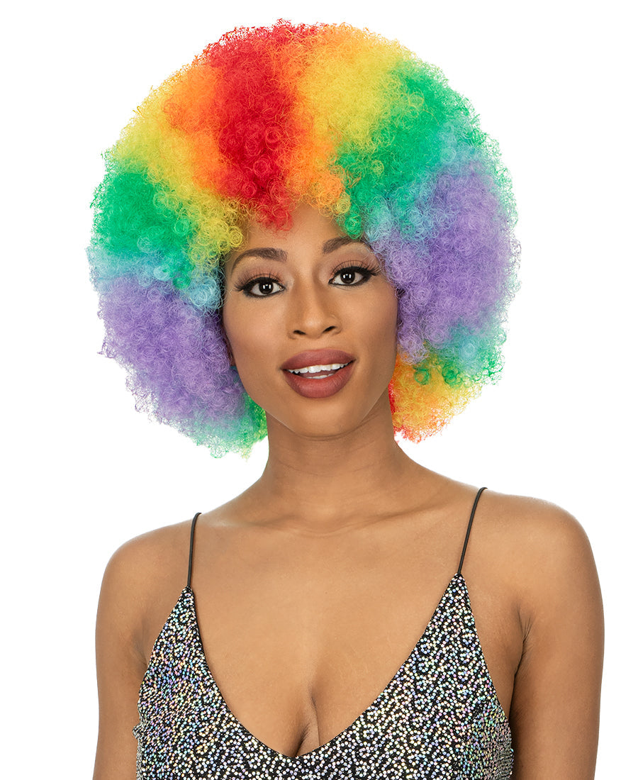 Woman models New Born Free CUTIE 52 Wig, a short, full rainbow afro with tight curls.