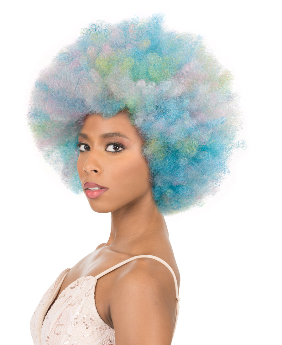 Person modeling a New Born Free CUTIE 52 Wig; a short, full, curly afro in mixed pastel blue, pink, and green colors.