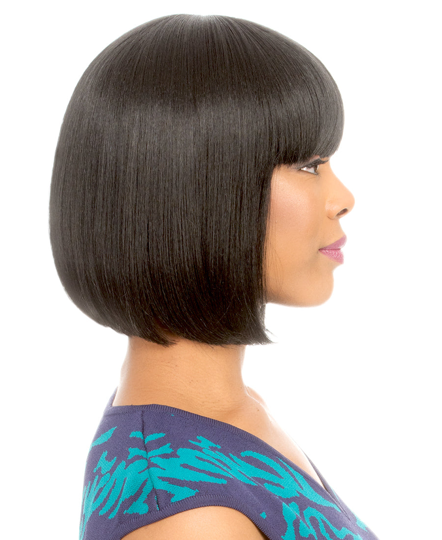 A woman models the New Born Free CUTIE TOO 112 Quick Style Wig: a sleek, chin-length black bob with bangs.